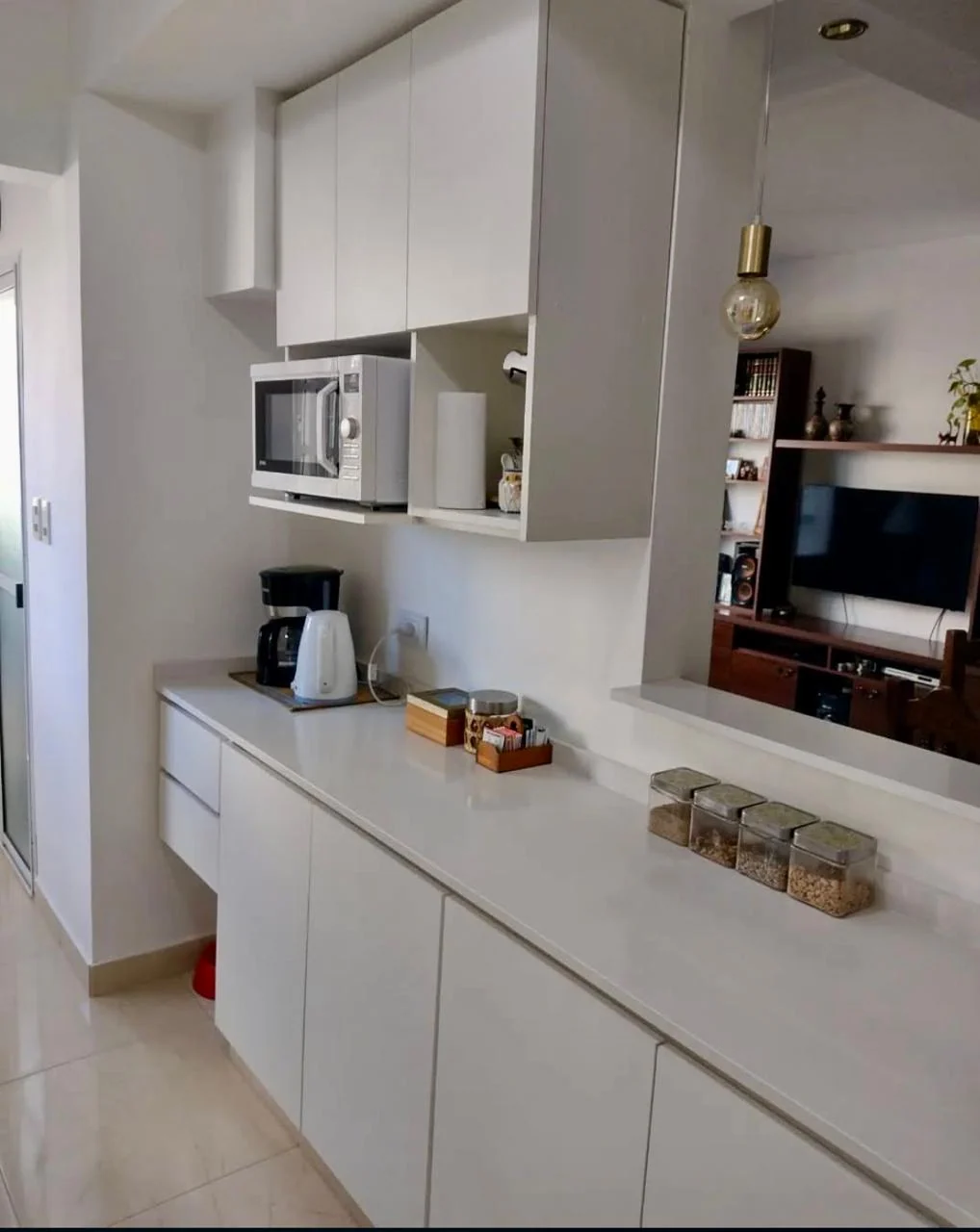 Mueble de cocina blanco con mesada de apoyo y hueco para microondas