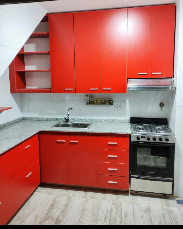 Cocina de frentes rojos con cajones, estantes y módulos altos