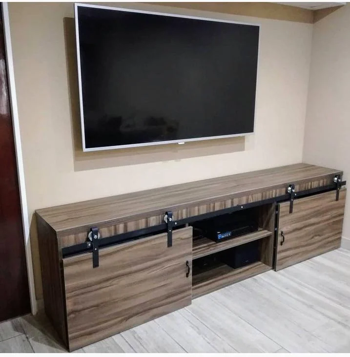 Mueble bajo de televisión de acabado madera con puertas corredizas y herrajes negros